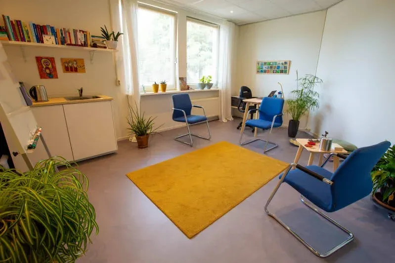 De spreekkamer van Nynke Groot in Leiden: met gele tapijt en blauwe stoelen